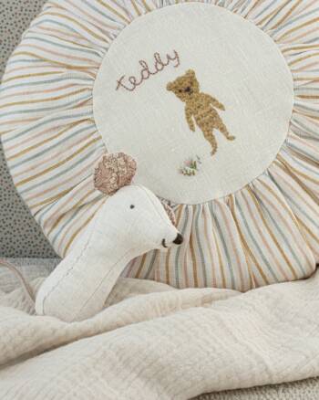 Hochet Souris Maileg Lullaby Friends posé sur un coussin brodé Teddy