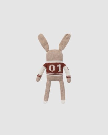 Vue de dos du doudou lapin Main Sauvage en laine baby alpaga, portant une veste de baseball rouge avec le chiffre 01.