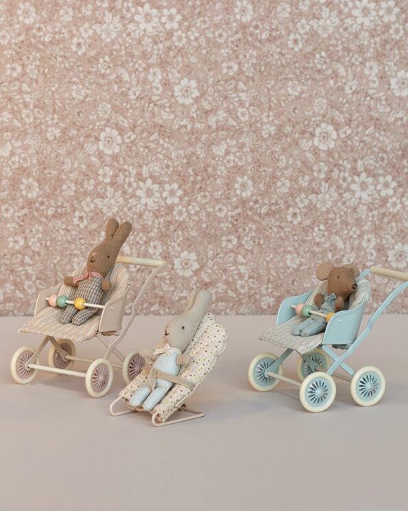 Trois poussettes Maileg avec bébés lapins et souris devant un fond fleuri, accessoires miniatures pour jeux d’imitation dans l’univers Maileg.