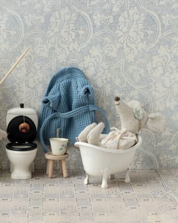 Souris Maileg prenant un bain dans une baignoire blanche en métal, entourée d’accessoires miniatures dans une salle de bain Maileg