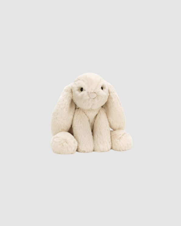 Peluche Smudge Rabbit Jellycat en position assise sur fond gris clair