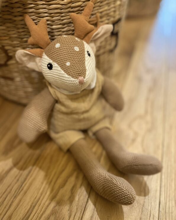 Peluche Woody Faon Egmont Toys en coton tricoté assise sur un parquet