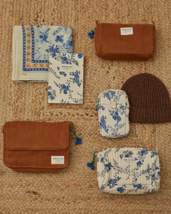 Foulard Orchid Bleu Émile et Ida avec trousses et bonnet en laine sur fond tressé