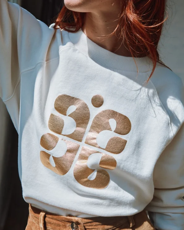 Sweat crème en coton bio avec logo doré Emile et Ida – porté par une femme