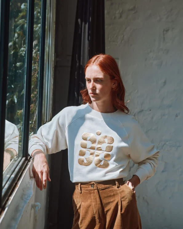 Femme portant le sweat logo doré Emile et Ida crème – collection automne hiver