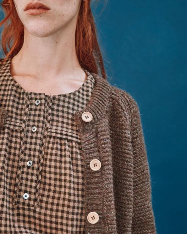 Zoom sur le cardigan en laine châtaigne Emile et Ida porté par une femme – Col rond et boutons bois