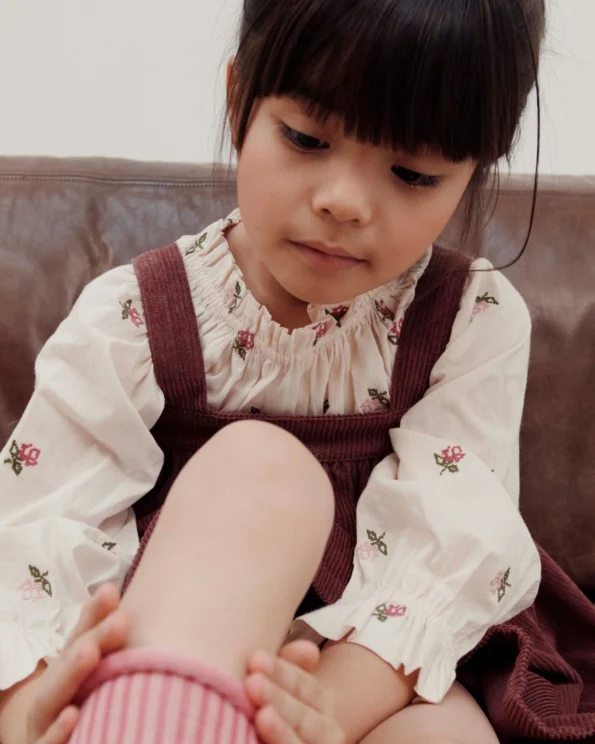 Enfant portant la blouse fleurs point de croix écru Émile et Ida – gros plan