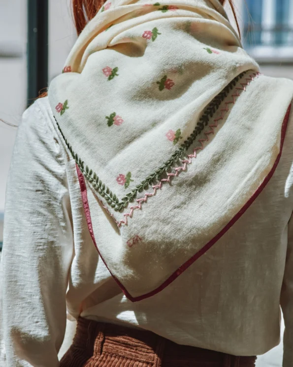 Détail du foulard brodé roses Emile et Ida vu de dos, porté sur les épaules avec bordure rose tyrien