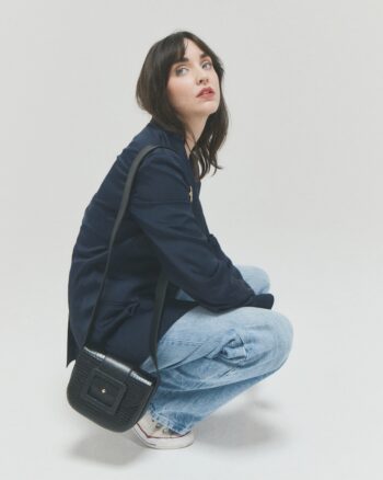 Sac Le June Mushu Herbert Frère Sœur noir porté en bandoulière par une femme, petit format élégant en cuir embossé