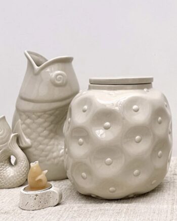 Vase Poisson couleur sable et pot rond en céramique Opjet Paris sur une table