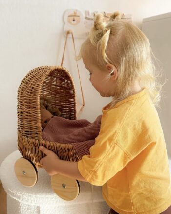 Enfant jouant avec le petit landau en osier Egmont Toys