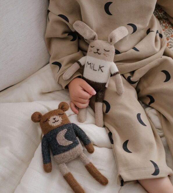 Doudous Ourson Midnight et Lapin Milk Main Sauvage x Organic Zoo tenus par un enfant – tricot à la main en laine baby alpaga naturelle