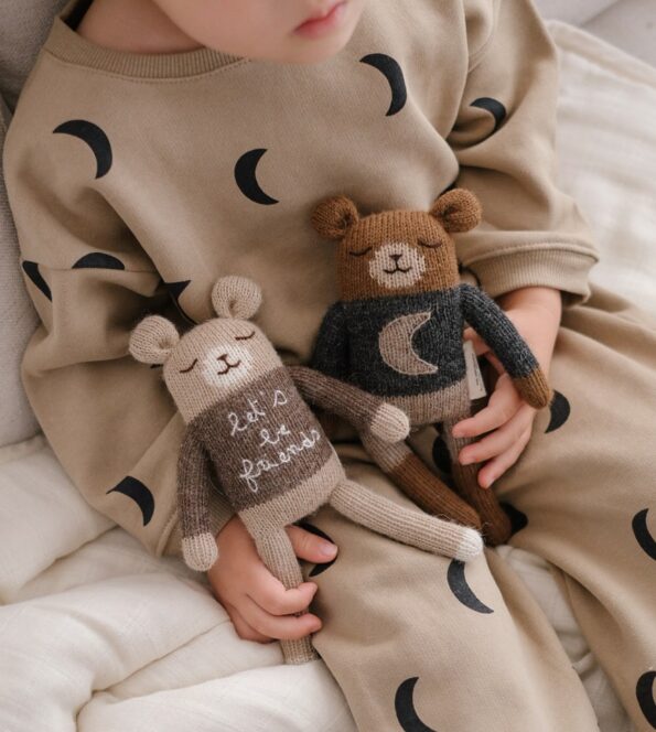 Doudous Ourson Midnight et Little Dreamer Main Sauvage x Organic Zoo tenus par un enfant – tricot à la main en laine baby alpaga naturelle