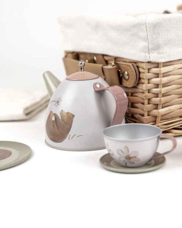Théière et tasse en métal du set de thé forêt Egmont Toys devant la valise en osier – jouet d’imitation pour enfants
