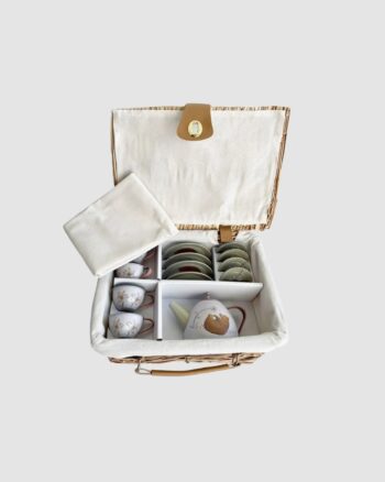 Set de thé en métal forêt Egmont Toys présenté dans une valise en osier ouverte avec tasses, assiettes et théière pour enfants