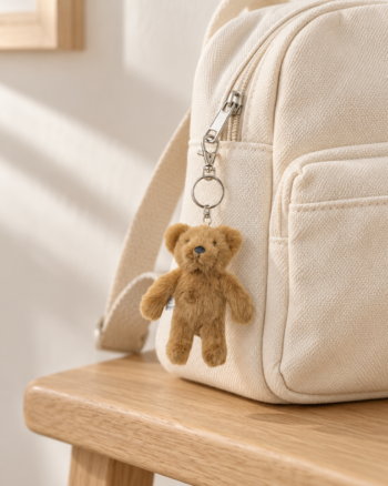 Porte-clés ours Alfredo Liewood Golden Caramel accroché à un sac à dos