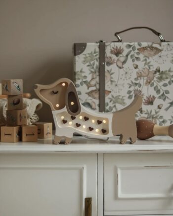 Lampe chien Puppy Little Lights sur une commode blanche avec valise fleurie