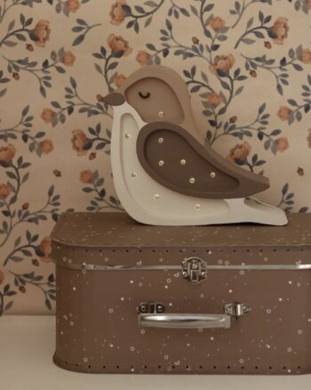 Veilleuse oiseau Little Lights Coffee Beige devant un papier peint fleuri