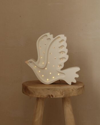 Lampe veilleuse colombe Little Lights blanche allumée sur un tabouret en bois
