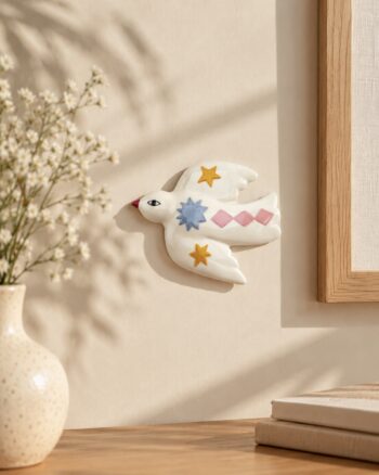 Décoration murale Oiseau Étoile Opjet en céramique blanche sur un mur beige