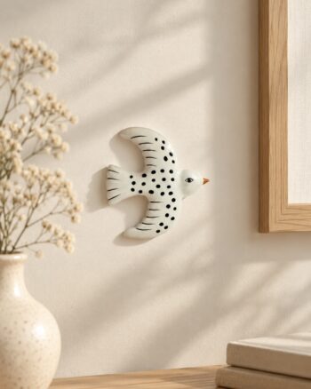 Décoration murale oiseau blanc à pois Opjet sur un mur beige