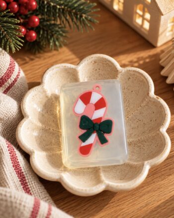 Savon sucre d’orge Ludi Soap dans une coupelle fleur en céramique beige avec décoration de Noël.